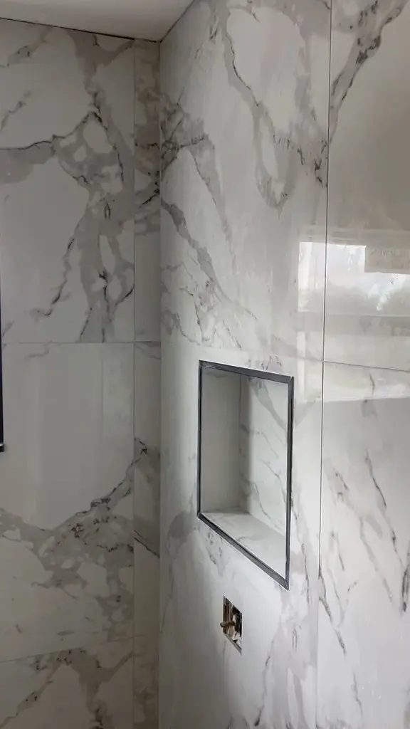Marble-look shower with a recessed niche